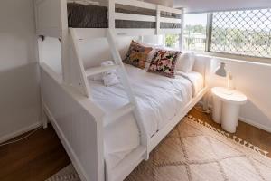a white bunk bed in a room with a window at Belle Vue - 4brm 2bth AC Pool Views in Eimeo