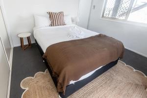 a bedroom with a bed with a blanket and a window at Belle Vue - 4brm 2bth AC Pool Views in Eimeo