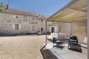 a patio with chairs and a table in front of a building at Le Vallon in Mondion
