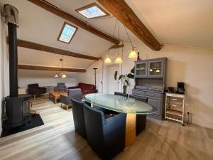a kitchen and living room with a table and chairs at Gîte Le Pré Doux in Ambert +5 photos
