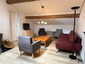 a living room with a couch and chairs and a table at Gîte Le Pré Doux in Ambert