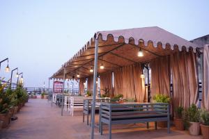 a restaurant with tables and chairs under a canopy at House M Lodge in Sawāi Mādhopur