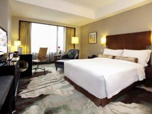 a hotel room with a large bed and a desk at Grand Mercure Beijing Central in Beijing
