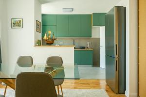 a kitchen with green cabinets and a glass table at Apartments Danilo in Herceg-Novi