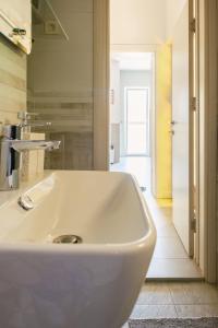 a white sink in a bathroom with a hallway at Apartments Danilo in Herceg-Novi +21 photos