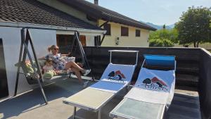 a woman and a child sitting on a swing and two chairs at C'Amunin Casa Vacanze in Chiuro +7 photos