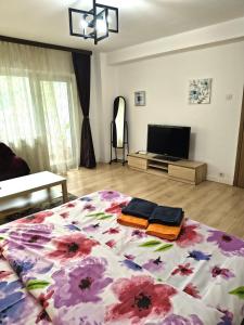 a bedroom with a large bed with a flower pattern at Gamma Group Sud in Bucharest