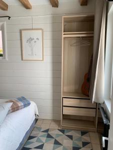 a bedroom with a bed and a closet with a guitar at Le Petit Musée in Loches