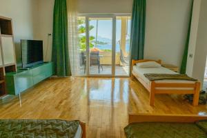 a bedroom with a bed and a television and a balcony at Apartments Danilo in Herceg-Novi