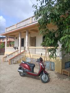 a red scooter parked in front of a house at Basant - Madhu in Alibaug