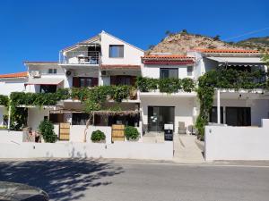 a white apartment building with plants on it at Galini Studios & Apartments-Adults only in Sougia