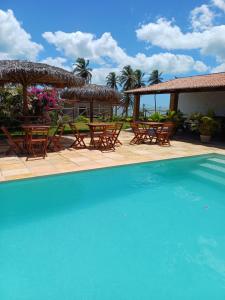 a pool with chairs and tables and umbrellas at Pousada Makai - Cajueiro da Praia in Barra Grande