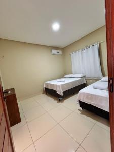 a room with two beds and a window at Pousada Makai - Cajueiro da Praia in Barra Grande +25 photos