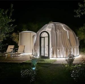 a gazebo with a table and chairs on a deck at night at Glamping & Spa Luna Azzurra in Sulmona