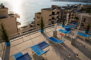 a group of blue chairs on a balcony overlooking the water at Hersol Skyline in Durrës
