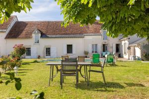 a table and chairs in front of a house at Chambres D'hôtes La Maison Rouge - in Contres