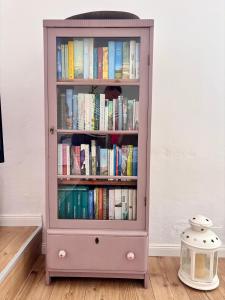 a pink book shelf filled with books in a room at Ferienwohnung Zeitweise in Bünsdorf am Wittensee in Bünsdorf