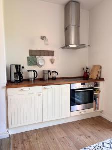 a kitchen with white cabinets and a microwave at Ferienwohnung Zeitweise in Bünsdorf am Wittensee in Bünsdorf +19 photos