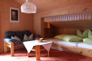 a bedroom with a bed and a couch and a table at Haus Danna in Sankt Gallenkirch