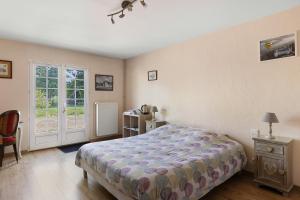 a bedroom with a bed and a sliding glass door at Chambres D'hôtes La Maison Rouge - in Contres