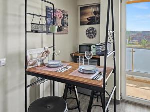 a room with a table and a shelf with plates and glasses at Konstanzer 95 - Cozy Studio - Iulius Mall - AC in Iaşi