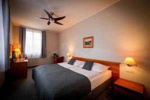 a bedroom with a bed with a ceiling fan at LH Hotel Dvořák Tábor Congress & Wellness in Tábor