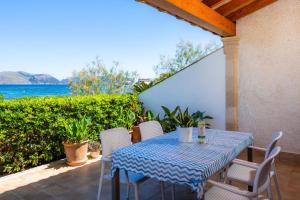 a table and chairs on a patio with the ocean at Can Figó in Alcudia