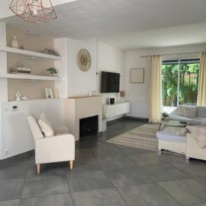a living room with white furniture and a fireplace at Maison familiale dans le var in Brignoles +3 photos
