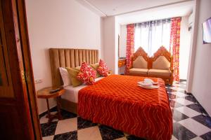 a bedroom with a bed and a couch and a window at Maison d'hôte Bousaid in Chefchaouen +90 photos