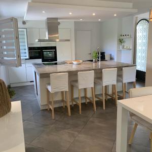 a kitchen with a large kitchen island with white cabinets at Maison familiale dans le var in Brignoles