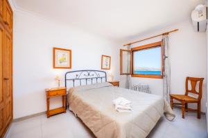 a bedroom with a bed and a window and a chair at Can Figó in Alcudia