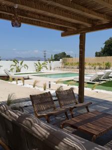 two wicker chairs sitting under a pavilion near a pool at Kosnian Villa with Jeep Renegade Hybrid in Zipárion