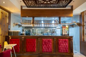a bar with red seats in a restaurant at Lanai Hotel فندق لاناي in Jeddah