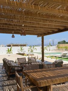 a wooden table and chairs under a wooden umbrella at Kosnian Villa with Jeep Renegade Hybrid in Zipárion