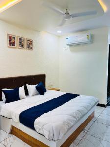 a bedroom with a large bed with blue and white pillows at Happy Rooms in Siddhapur