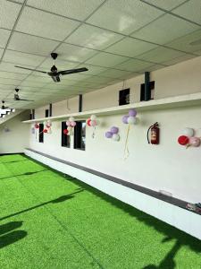 a room with a green floor and balloons on the wall at Happy Rooms in Siddhapur