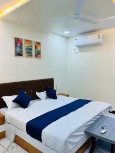 a bedroom with a large bed with blue pillows at Happy Rooms in Siddhapur