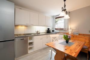 a kitchen with white cabinets and a wooden table at Wieschengrund in Neustadt in Holstein