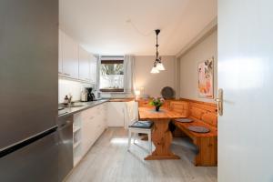 a kitchen with a wooden table in the middle at Wieschengrund in Neustadt in Holstein +22 photos