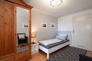 a small bedroom with a bed and a mirror at Wieschengrund in Neustadt in Holstein