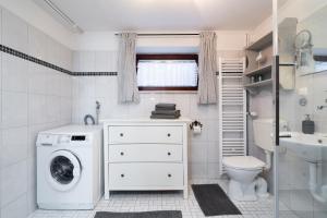 a white bathroom with a washing machine in it at Wieschengrund in Neustadt in Holstein