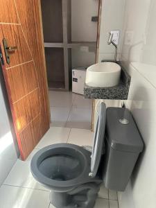 a bathroom with a black toilet and a sink at Pousada sonho real in Barreirinhas +18 photos