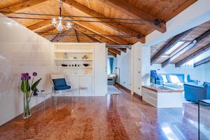a living room with wood ceilings and a couch and a chair at Ca' Del Monastero 9 Collection Spacious Apartment up to 5 Guests in Venice +26 photos