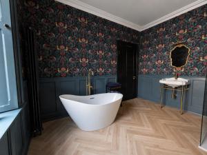 a bathroom with a white tub and floral wallpaper at NO 60 Sligo in Sligo +36 photos