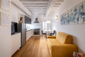 a living room with a couch and a kitchen at BF Glam-Apartments in Perugia