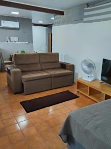 a living room with a couch and a fan at Espaçoso para casais in Vila Velha