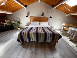 a bedroom with a large bed with a striped blanket at Atico de madera Apartamento en Rinlo, RIBADEO in Ribadeo