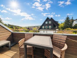 a patio with a table and chairs on a balcony at Chalet Platzhirsch in Braunlage