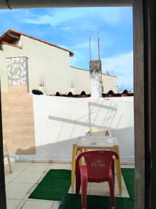 a table and a chair sitting on a patio at Espaçoso para casais in Vila Velha