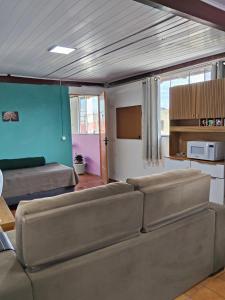 a living room with a couch and a kitchen at Espaçoso para casais in Vila Velha